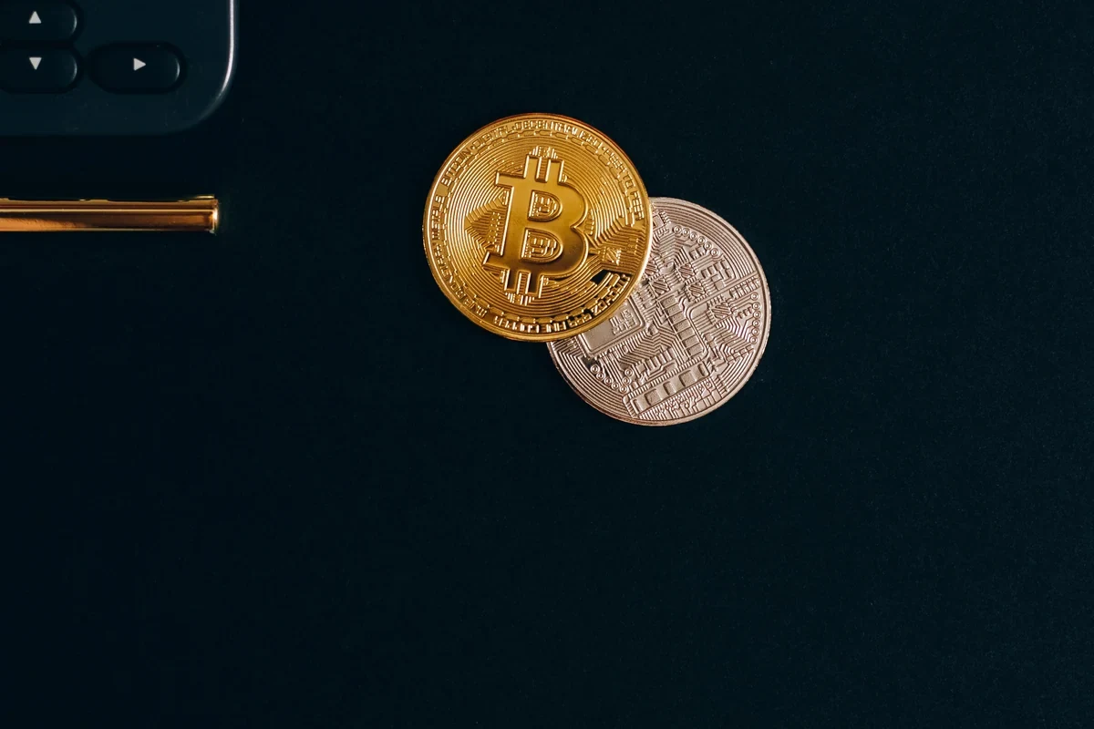 Gettoni decorativi Bitcoin ed Ethereum accanto a una calcolatrice